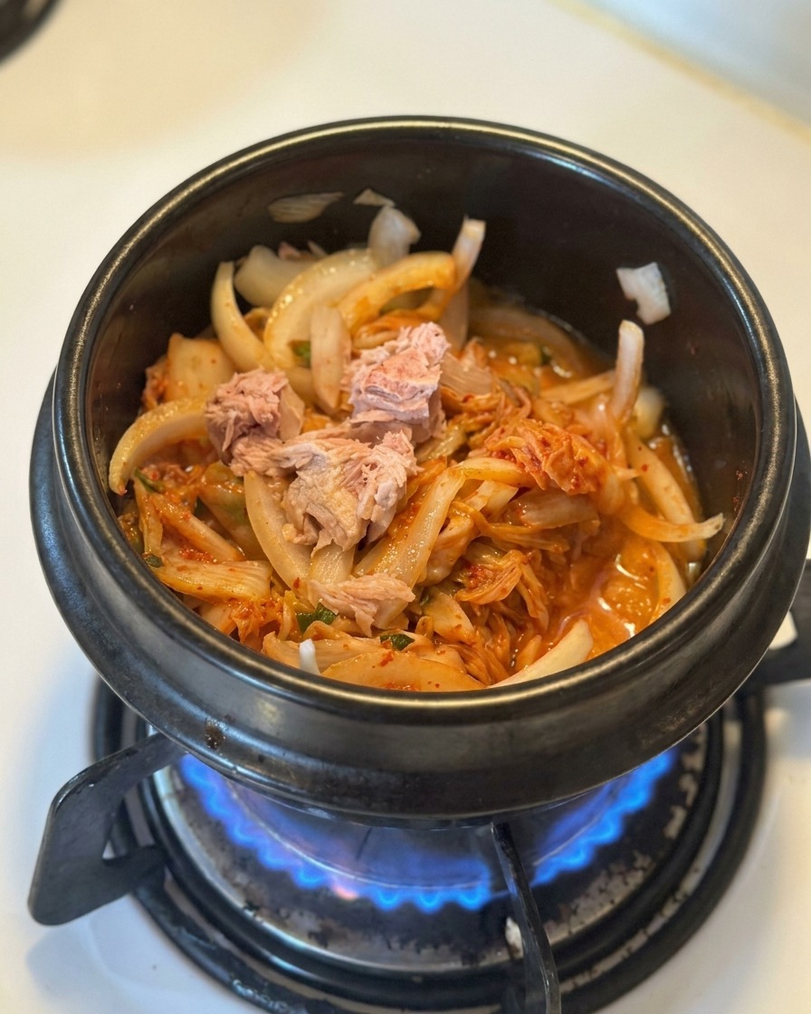 볶은 김치와 양파 위에 큼직한 참치 살코기를 올린 모습