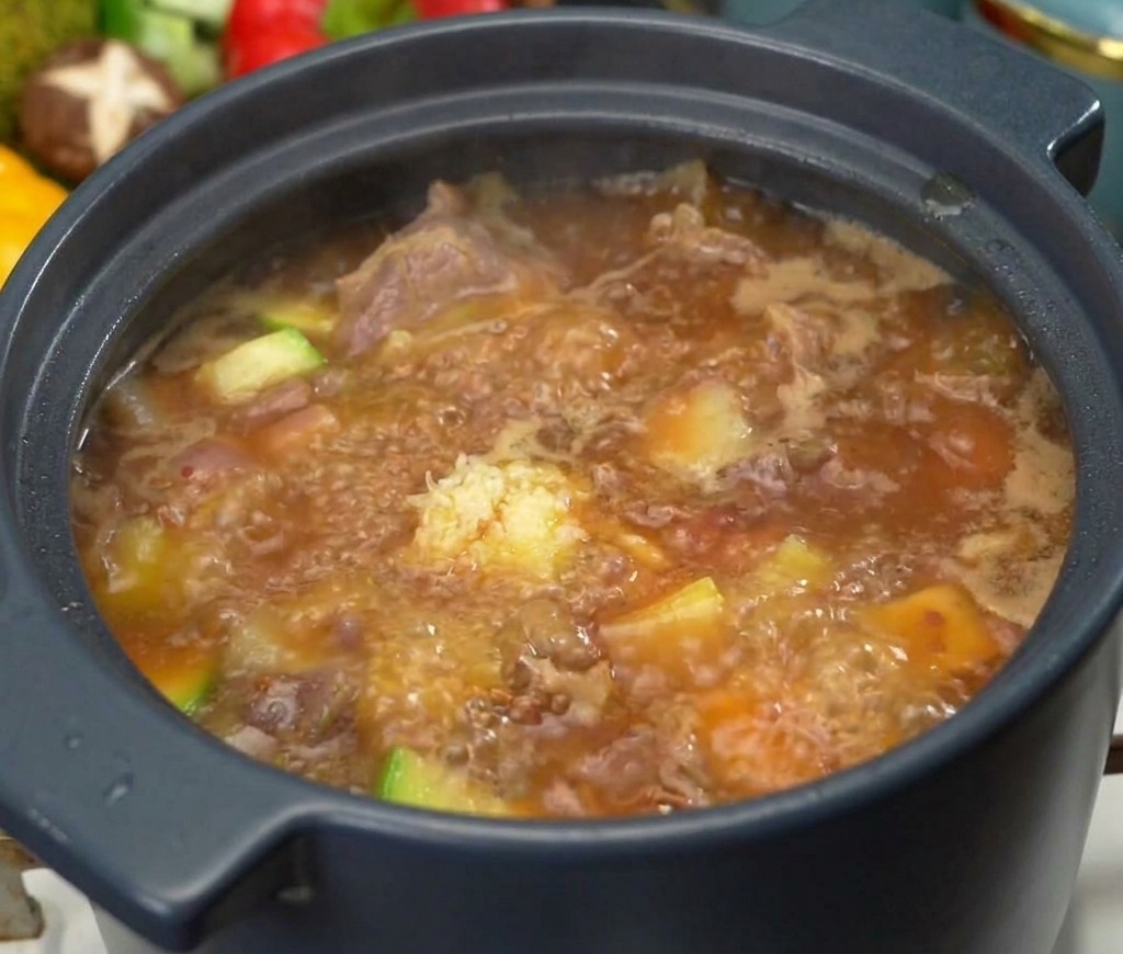 보글보글 끓는 소고기 된장찌개 위에 다진 마늘 한 큰술을 얹어 맛을 내는 모습
