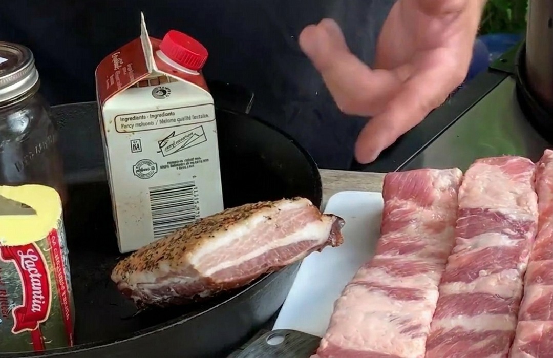 하얀 도마 위에 버터, 신선한 블루베리 등의 재료와 함께 길게 썰어놓은 생 돼지갈비 여러 줄.