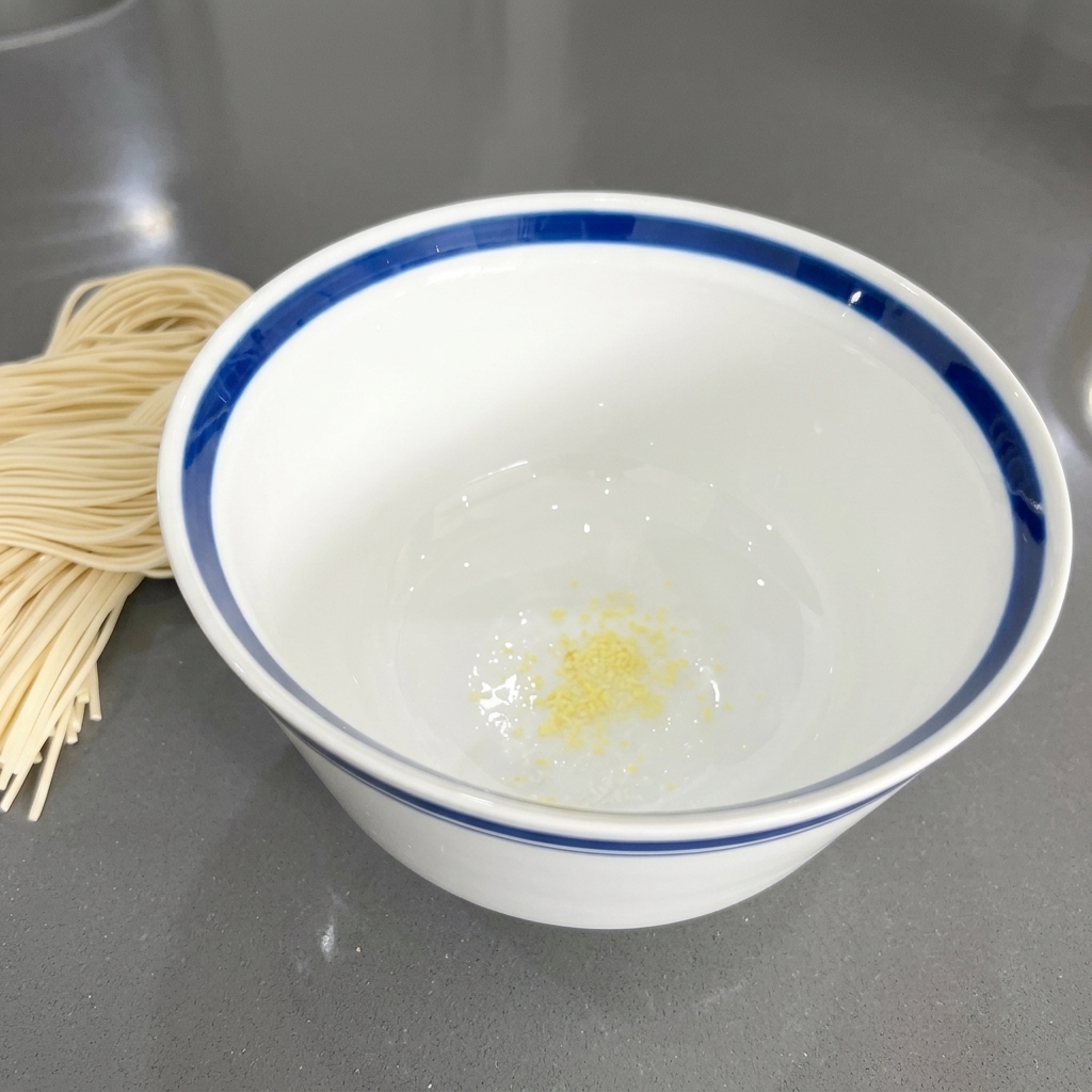 흰색 도자기 대접 바닥에 담겨 있는 노란빛의 다진 마늘 조각들
