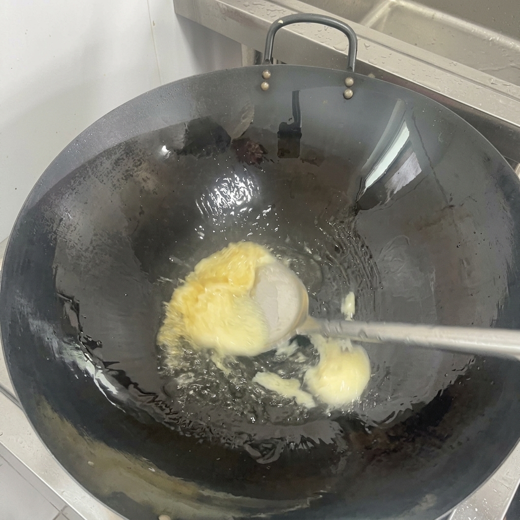 잘 길들여진 검은색 웍 바닥에서 하얀 고체 라드가 투명한 기름으로 녹아내리는 모습