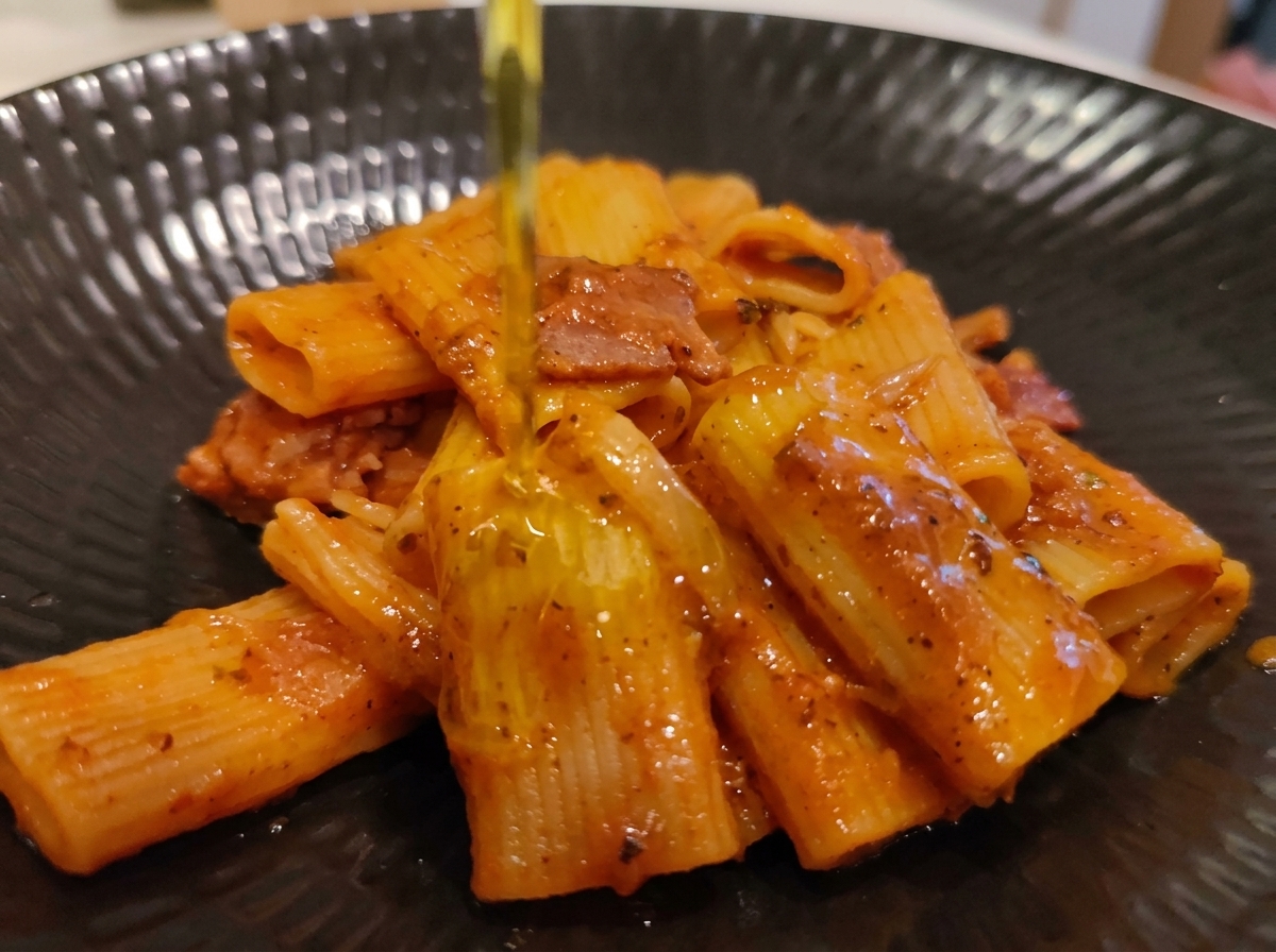 접시에 예쁘게 담아낸 리카토니 아마트리치아나 위에 엑스트라 버진 올리브유를 촉촉하게 떨어뜨리는 모습
