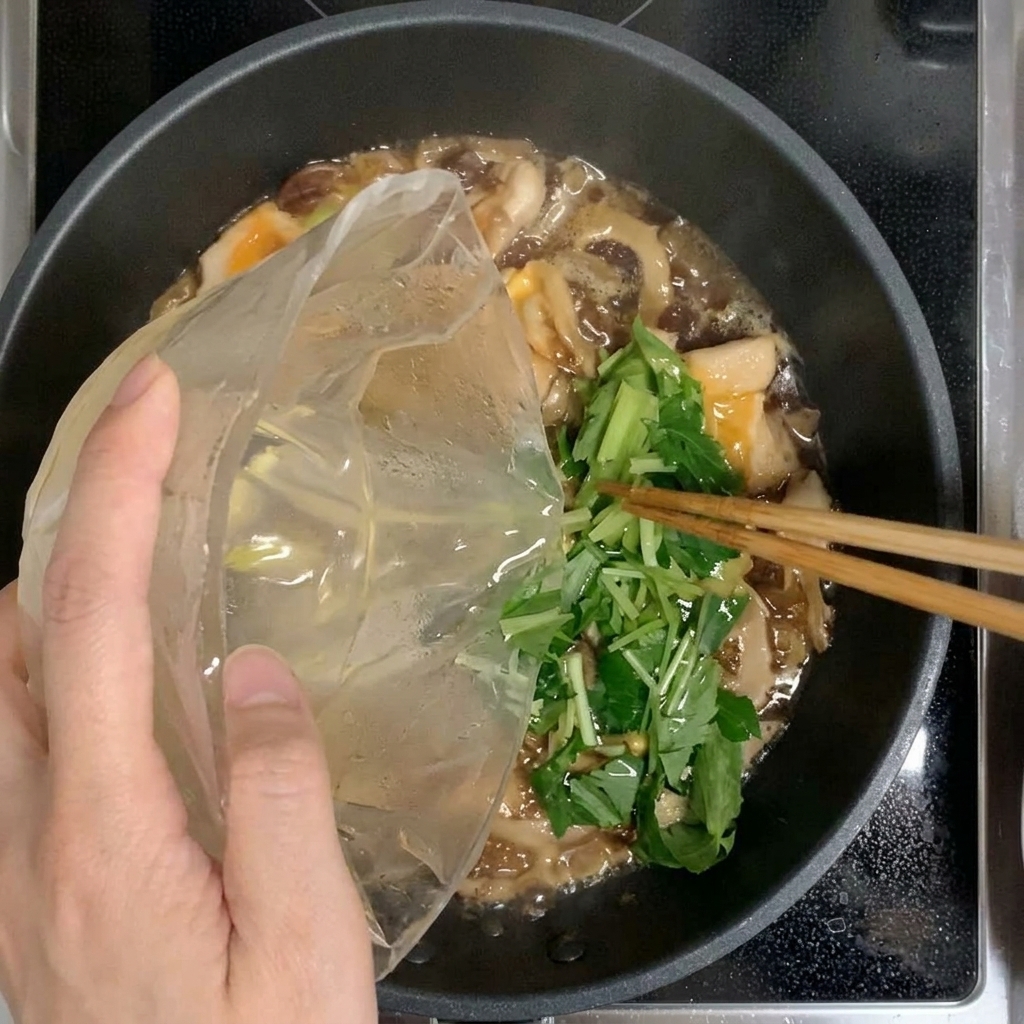 남은 3분의 1의 계란과 미츠바 혼합물을 팬에 추가로 붓는 모습.