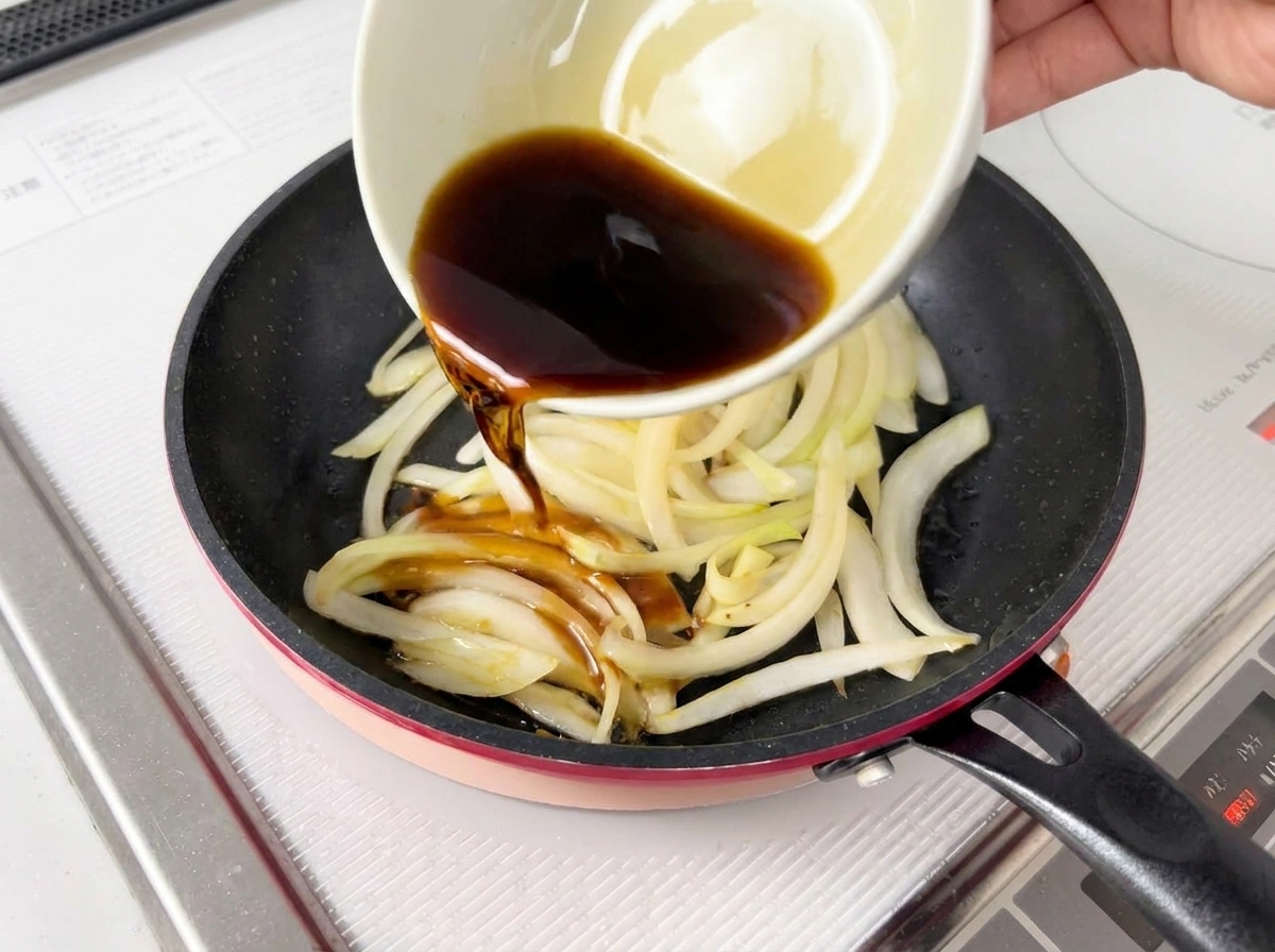 양파 위에 간장 베이스 소스를 붓는 모습.