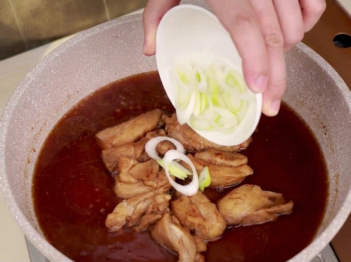 끓고 있는 팬에 썰어둔 대파를 흩뿌리는 모습