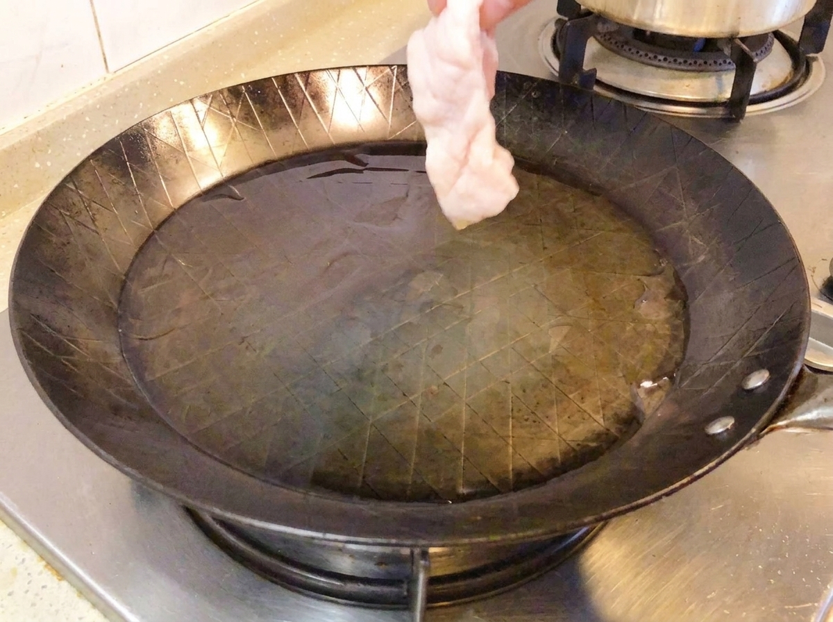 뜨거운 팬에 껍질을 아래로 하여 닭다리살을 올린 모습.