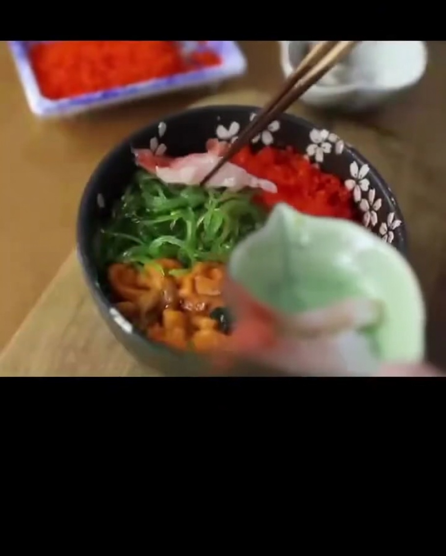반투명한 생 단새우를 해산물 덮밥 가장자리에 올리는 모습.