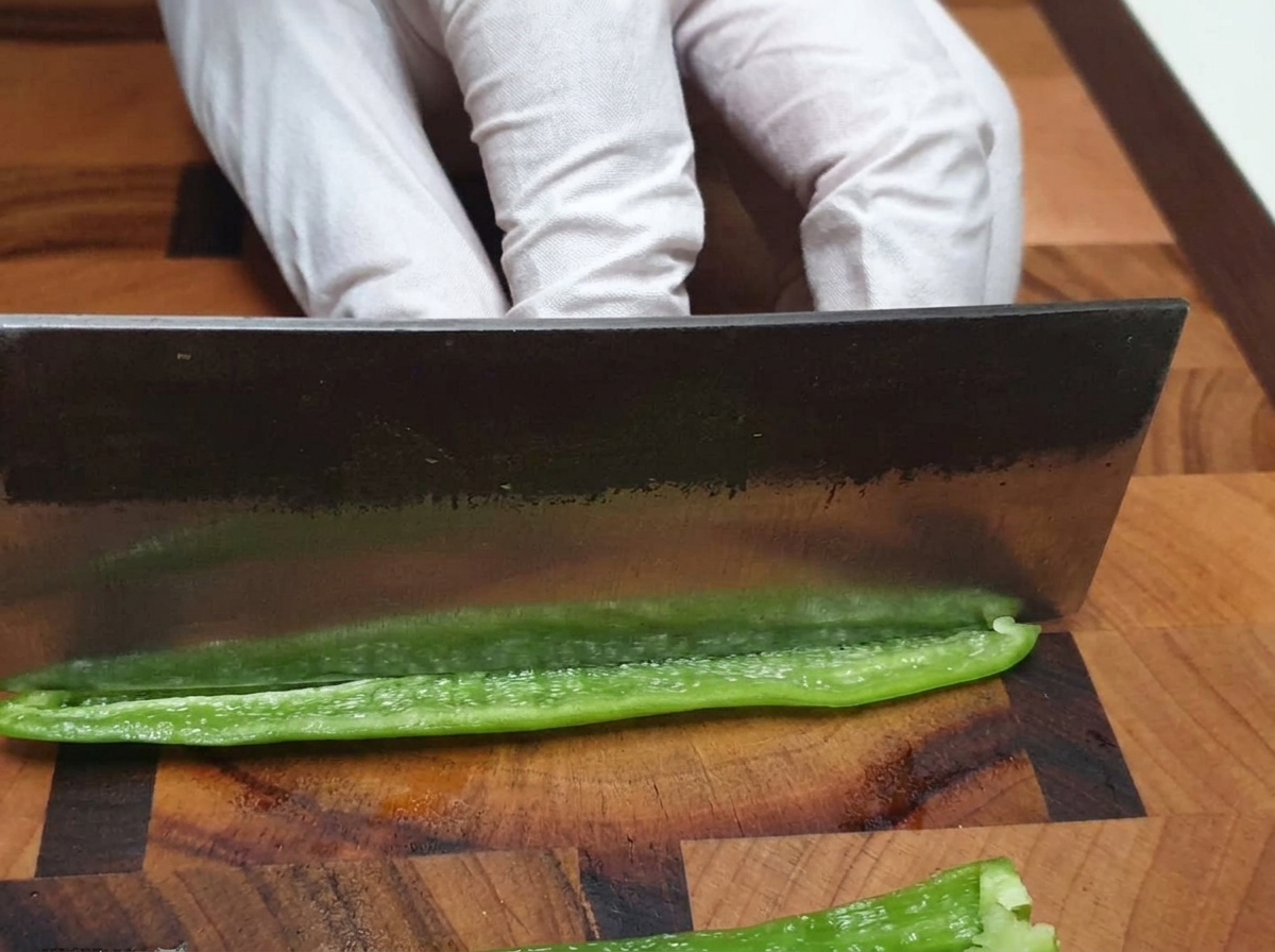 도마 위에서 칼로 청양고추를 잘게 다지는 모습.