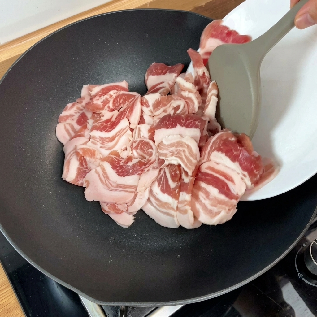 달궈진 팬에 삼겹살을 넣고 굽기 시작하는 모습.