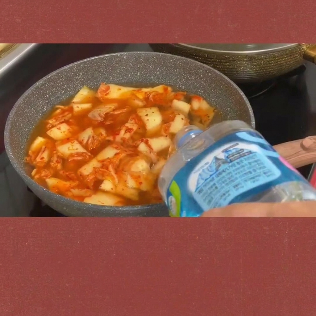 보글보글 끓는 김치찌개에 스팸 조각을 넣는 모습.