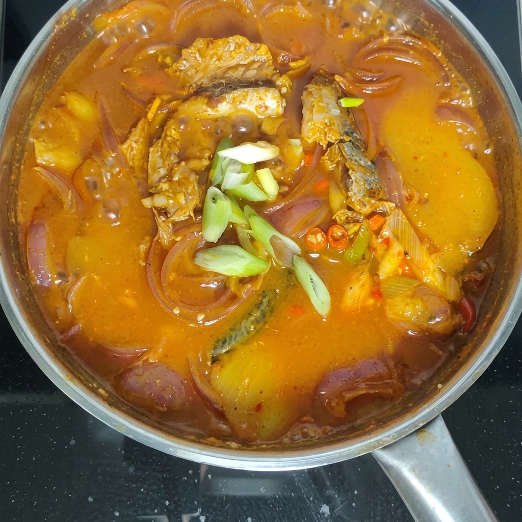 보글보글 끓는 조림 위로 썬 대파를 뿌리는 모습.