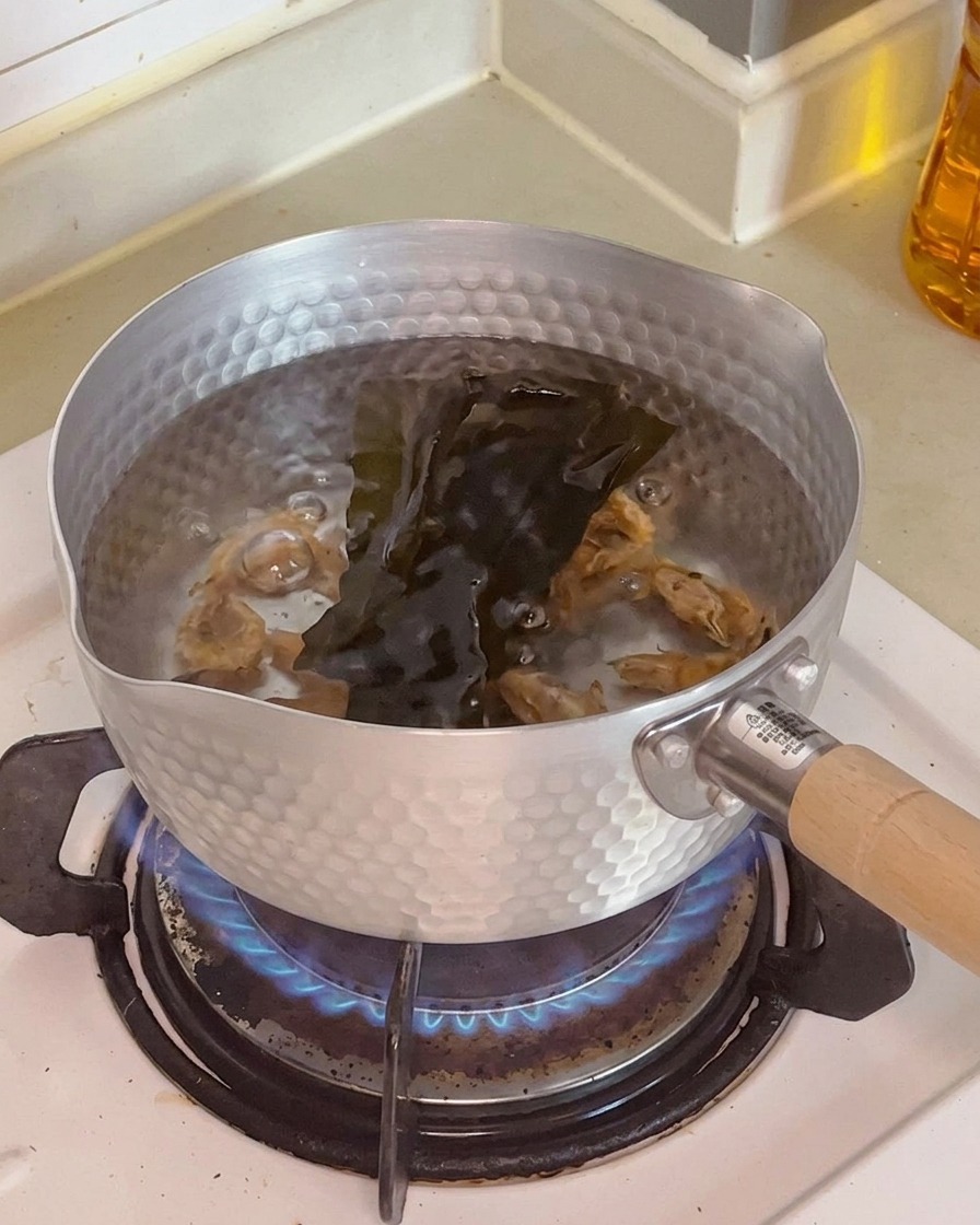 냄비 안의 물에 건새우와 다시마가 담겨 우러나고 있는 모습.