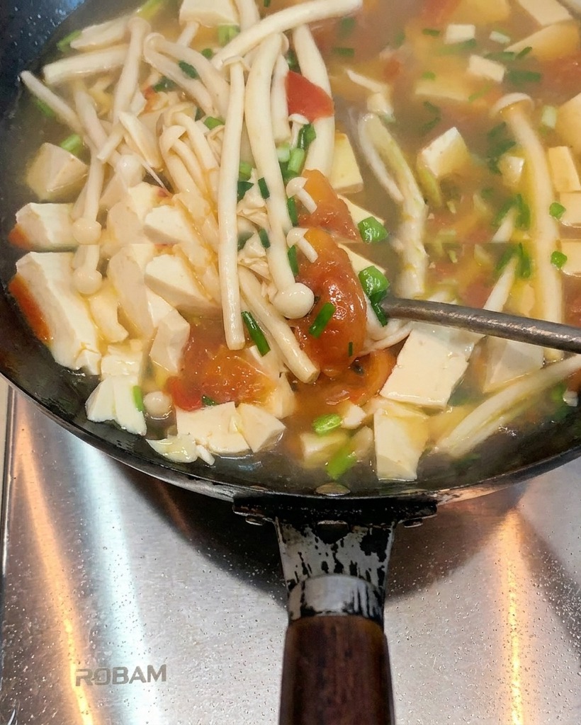 웍에서 녹은 라드에 볶아지며 부드러워지고 즙을 내는 토마토 모습.