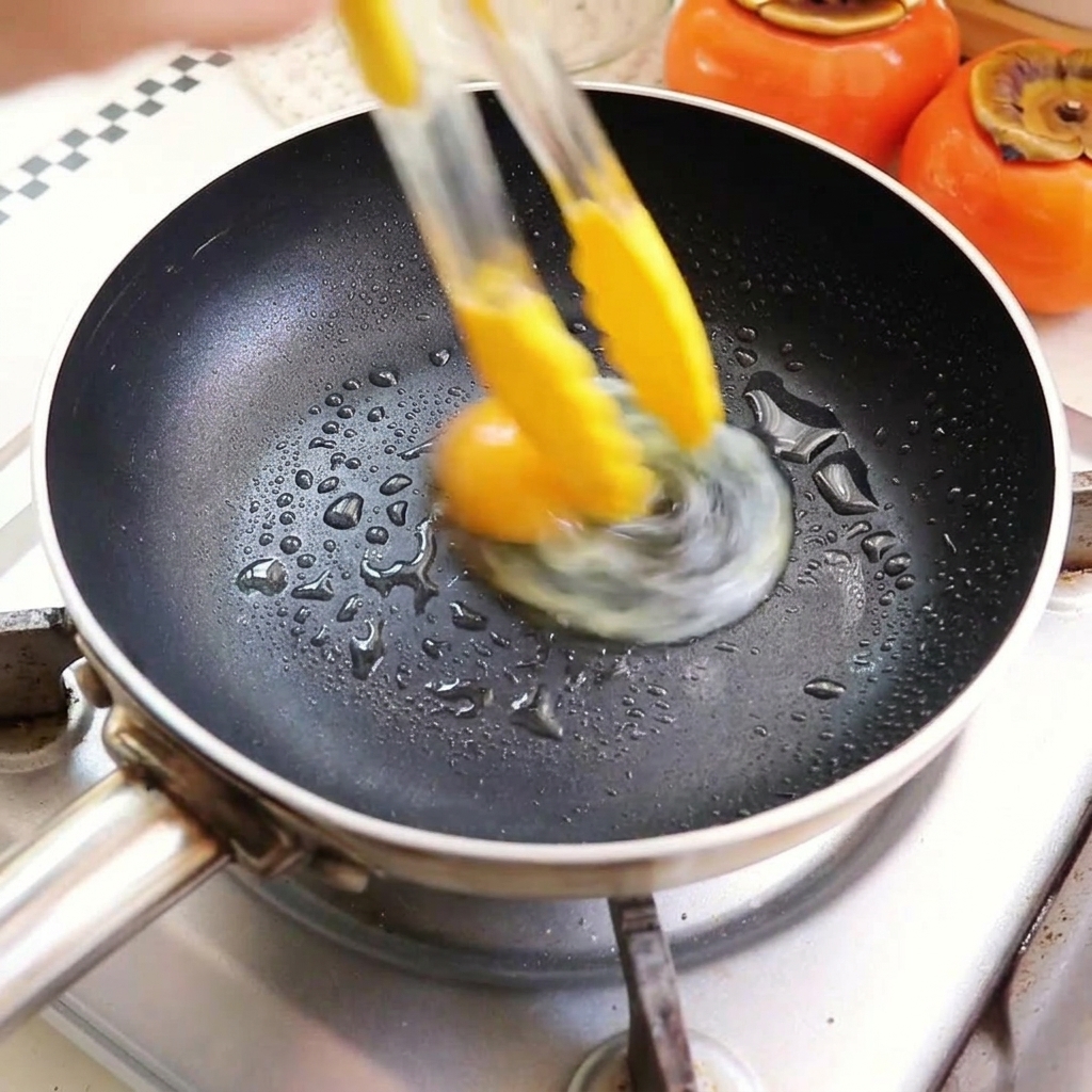 팬에 기름을 두르고 달걀을 부치는 모습.