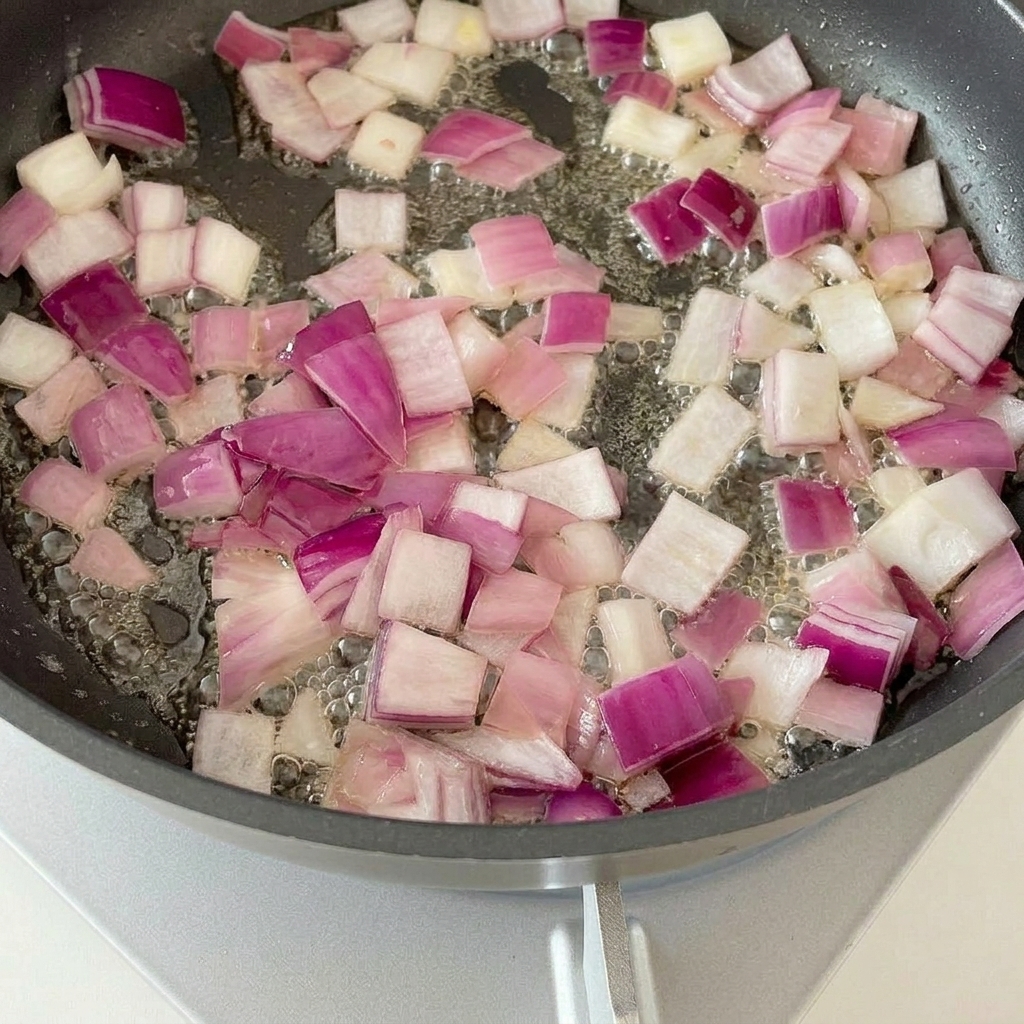팬에서 양파와 베이컨이 맛있게 볶아지는 모습.