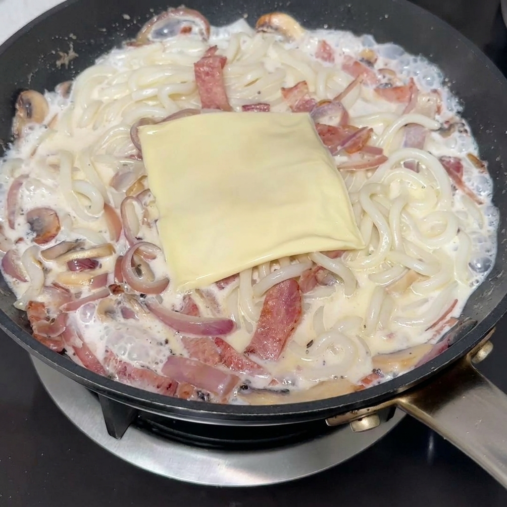 면 위에 슬라이스 치즈를 올리는 모습.