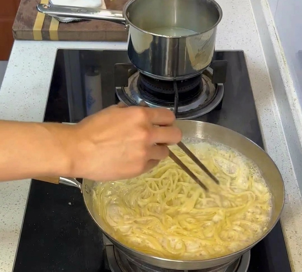 소스가 잘 배도록 면을 뒤섞는 모습.