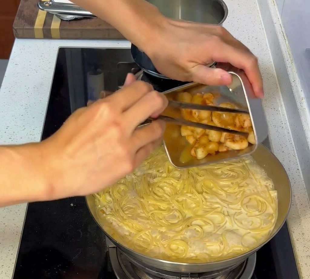 크림 파스타에 구워둔 해산물을 다시 넣는 모습.