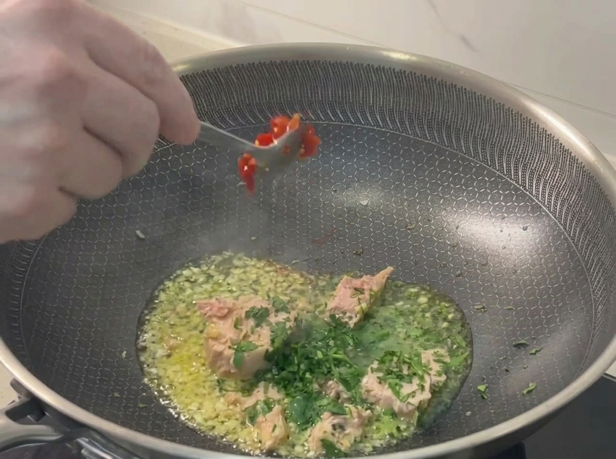 팬에 다진 붉은 고추를 넣는 모습.
