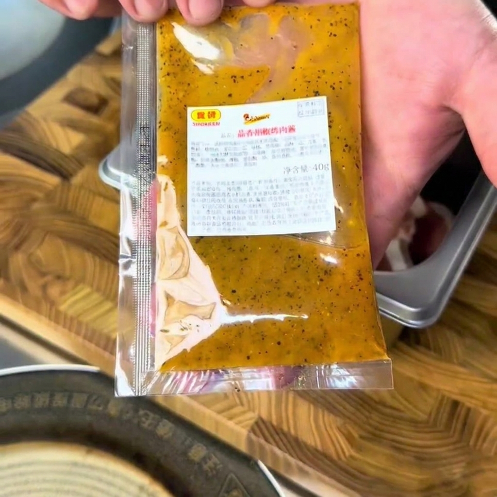 스테인리스 볼에 담긴 소고기 위에 갈릭 페퍼 바비큐 소스를 짜서 넣는 모습입니다.