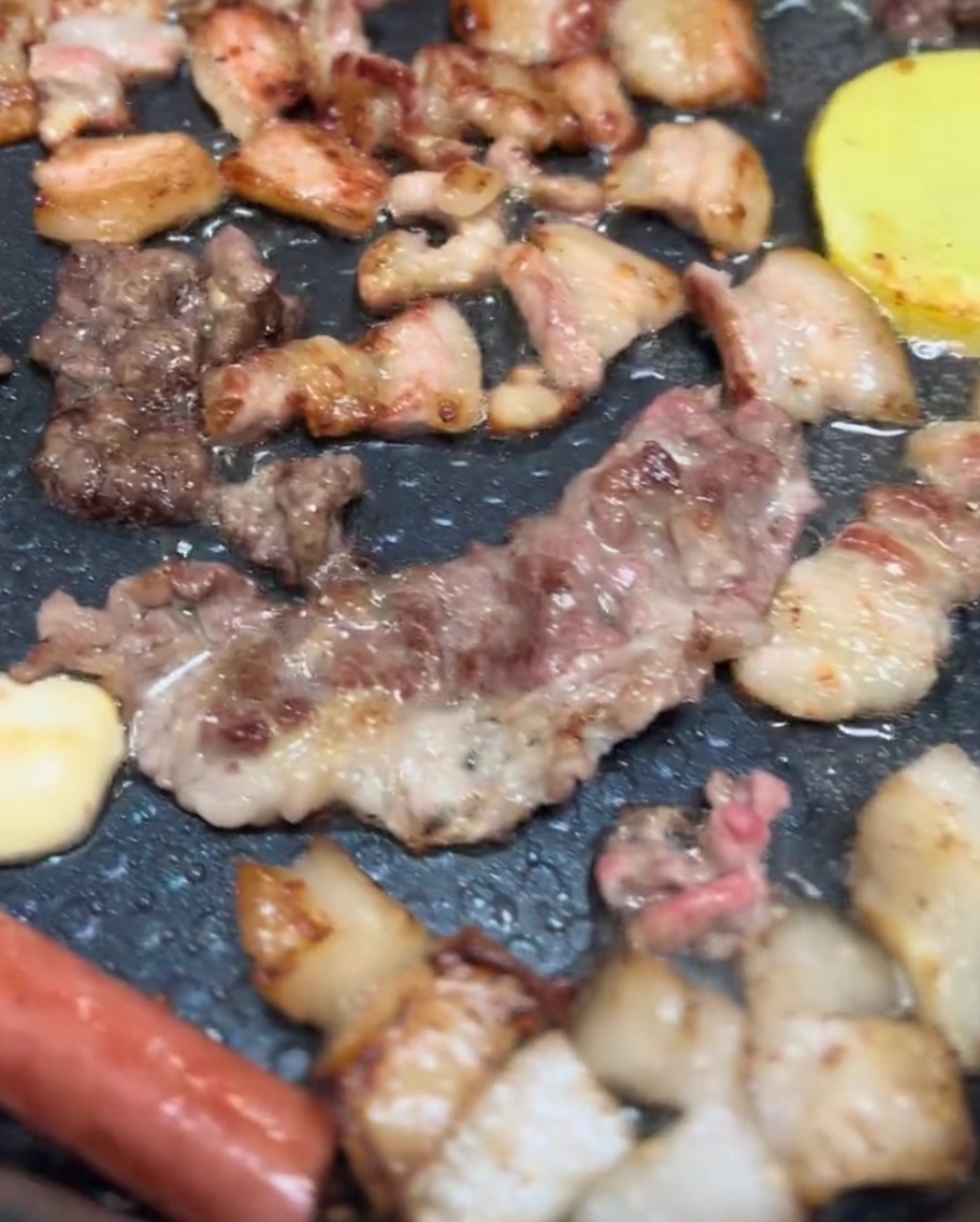전기 그릴에서 맛있게 구워지는 삼겹살, 양송이, 감자 슬라이스.