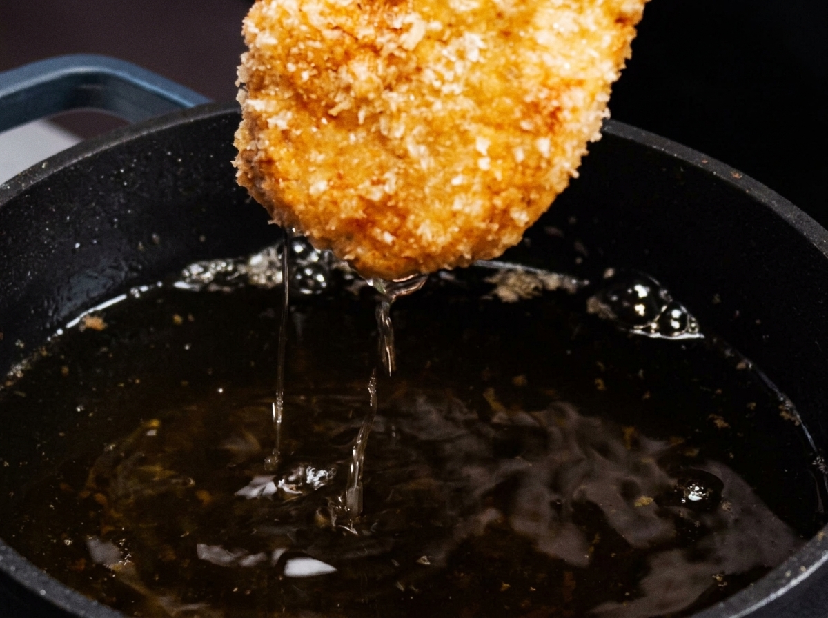 뜨거운 기름 팬에서 건져 올린 노릇하고 바삭한 치킨 까스.