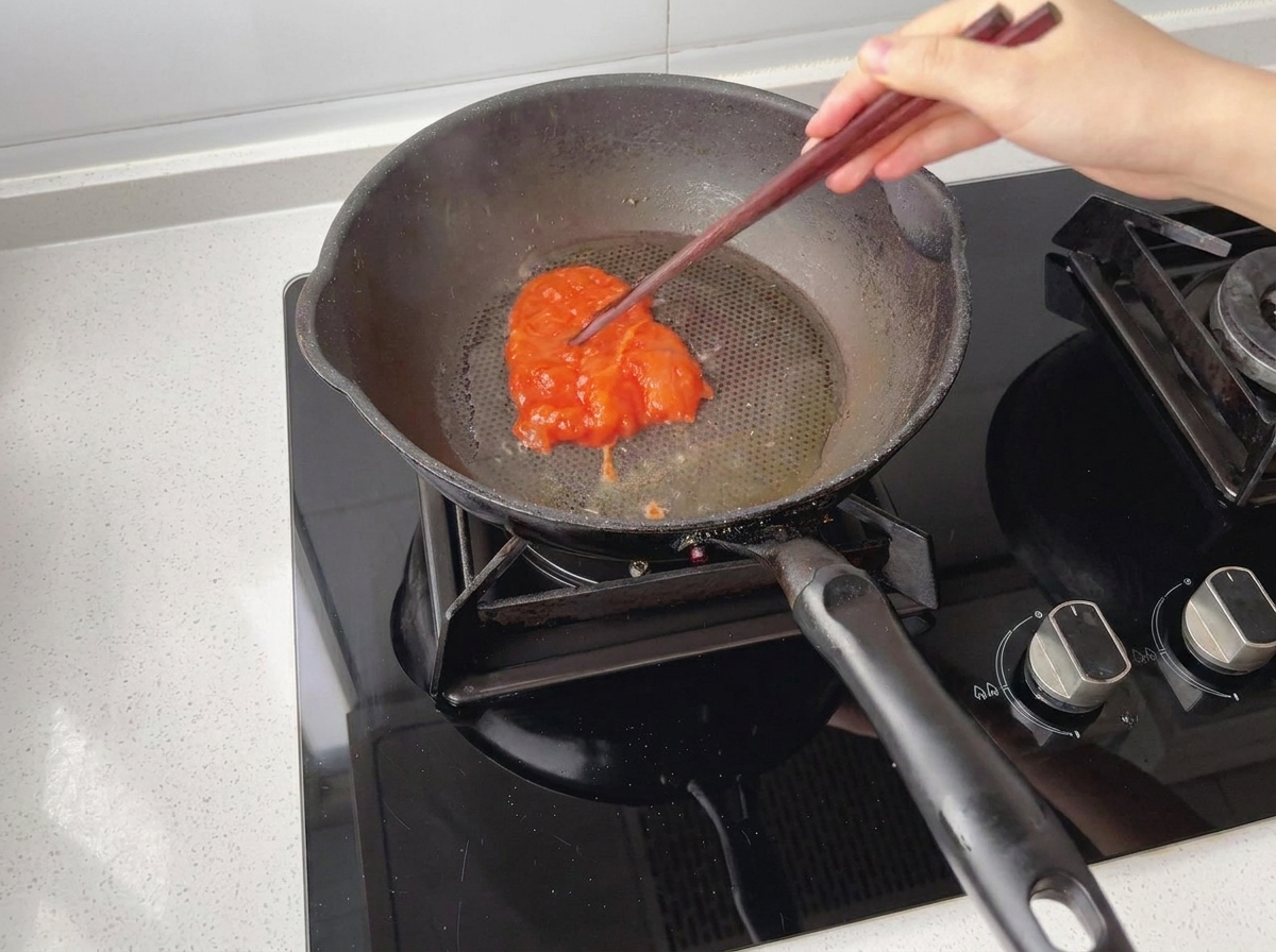 기름을 두르고 예열한 팬에 양념된 닭고기를 올리는 모습