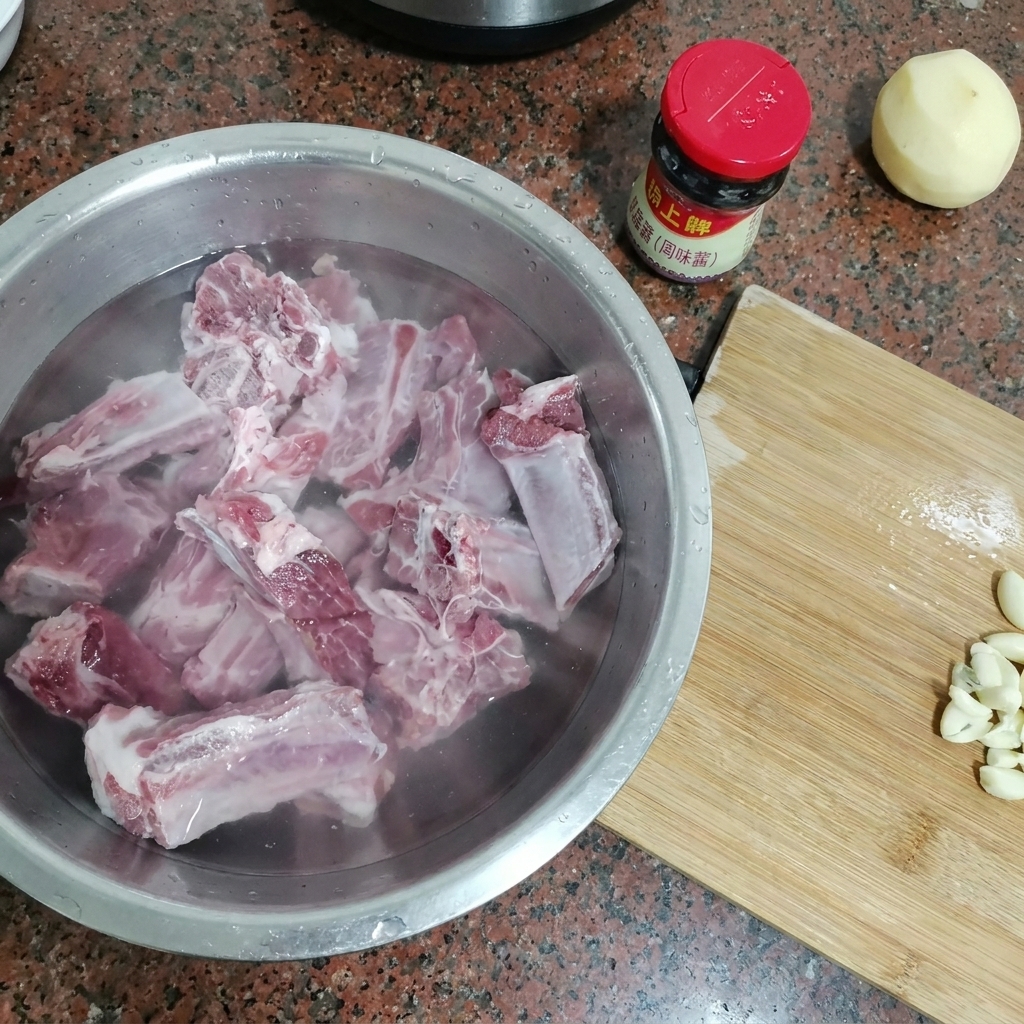 찬물이 담긴 큰 금속 볼에 담긴 생 돼지갈비.