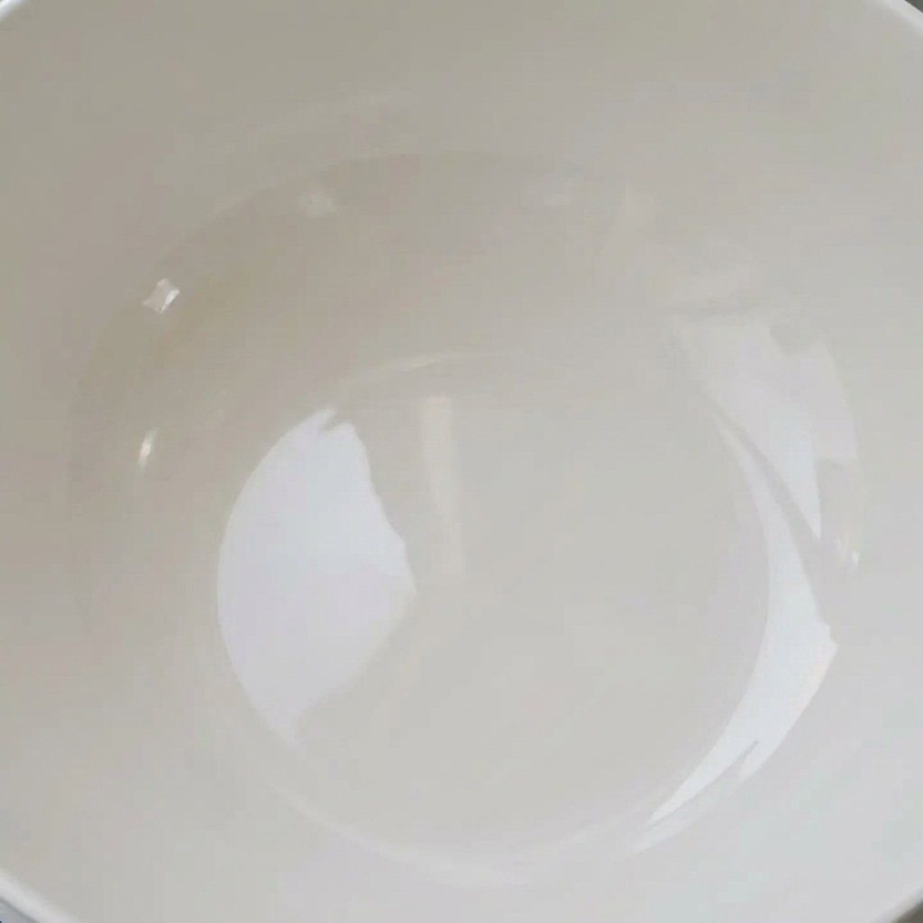 흰 그릇에 깨끗한 물을 채우고 바지락을 담가 해감하는 모습.