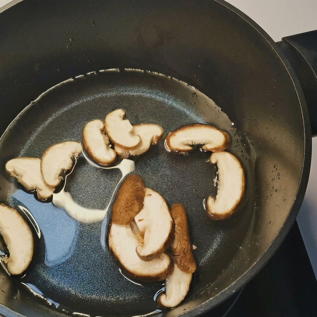 끓는 물에 슬라이스한 버섯, 숙주, 옥수수를 넣는 모습.