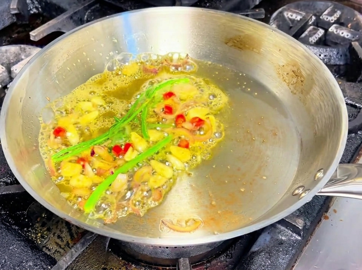 팬에서 조개와 화이트 와인이 마늘, 샬롯과 함께 끓고 있습니다.