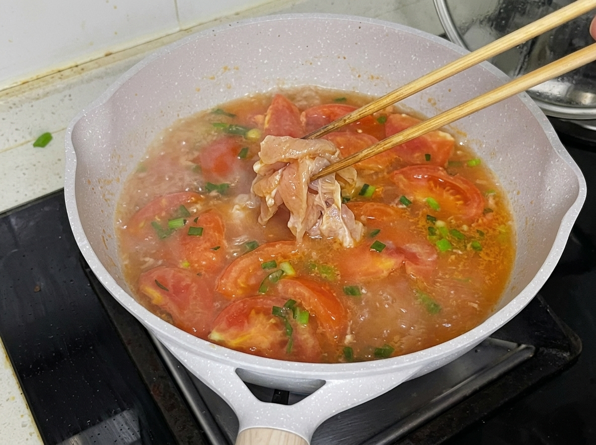 팔팔 끓는 육수에 젓가락으로 닭고기를 넣는 모습.