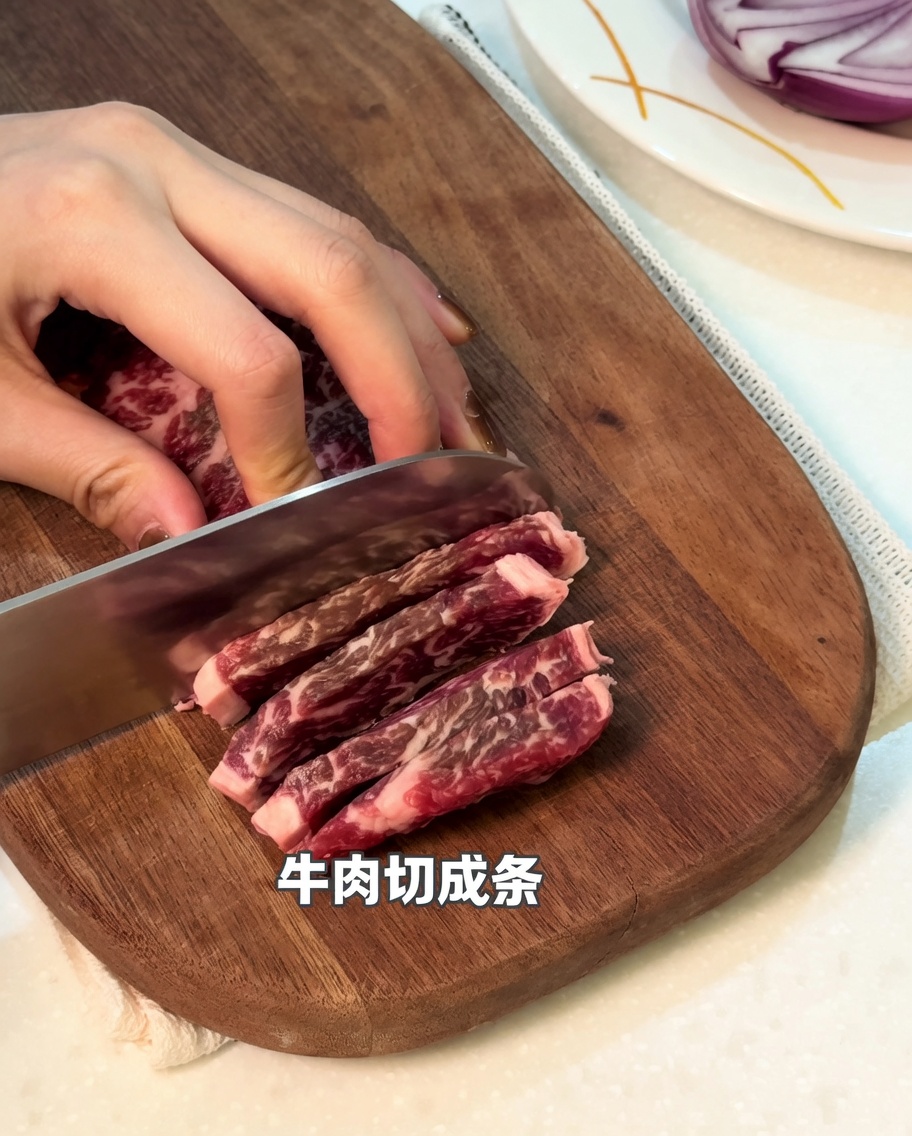 도마 위에서 소고기를 길쭉하게 썰고 있는 모습.