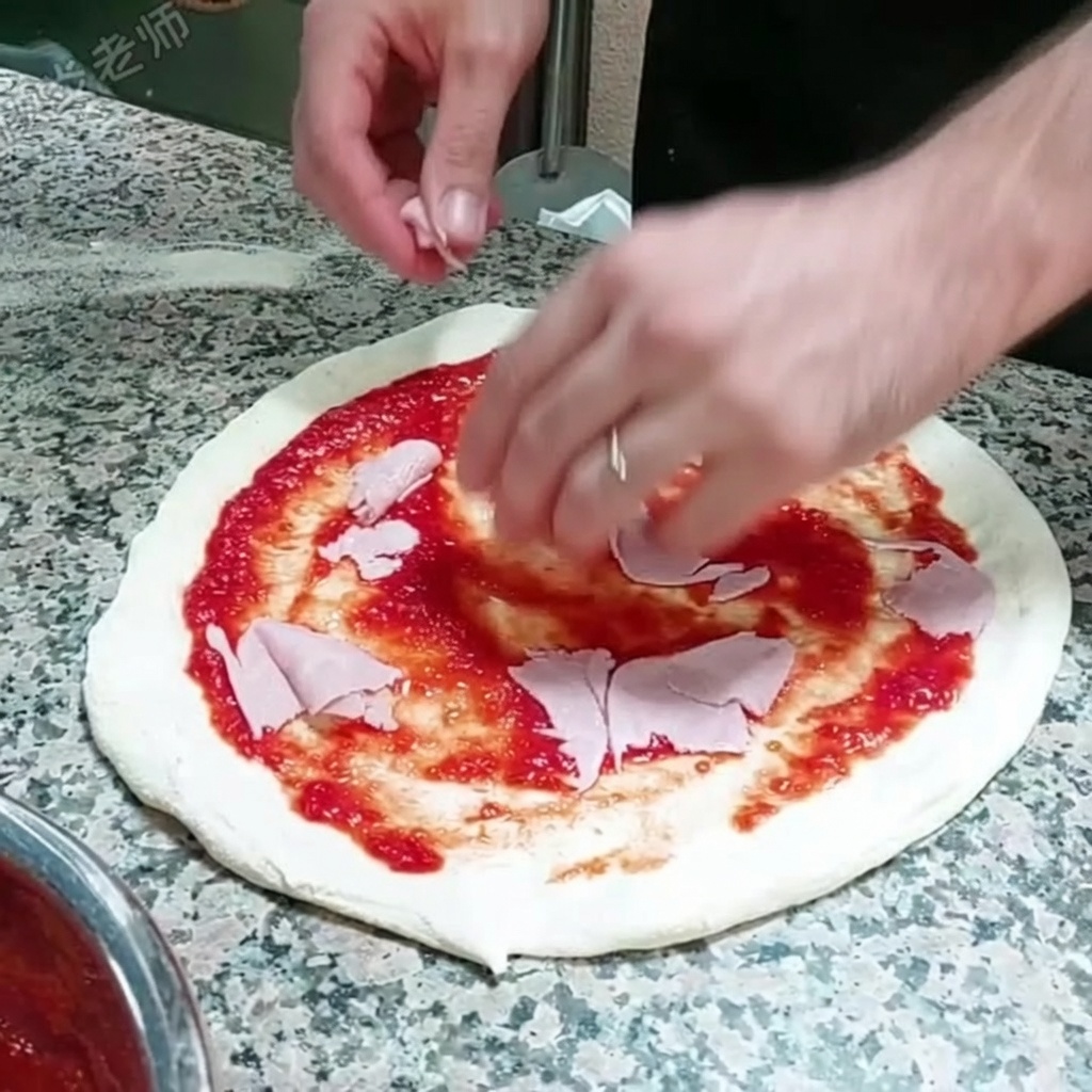 토마토 소스를 바른 피자 위에 얇게 썬 햄을 올리는 모습.