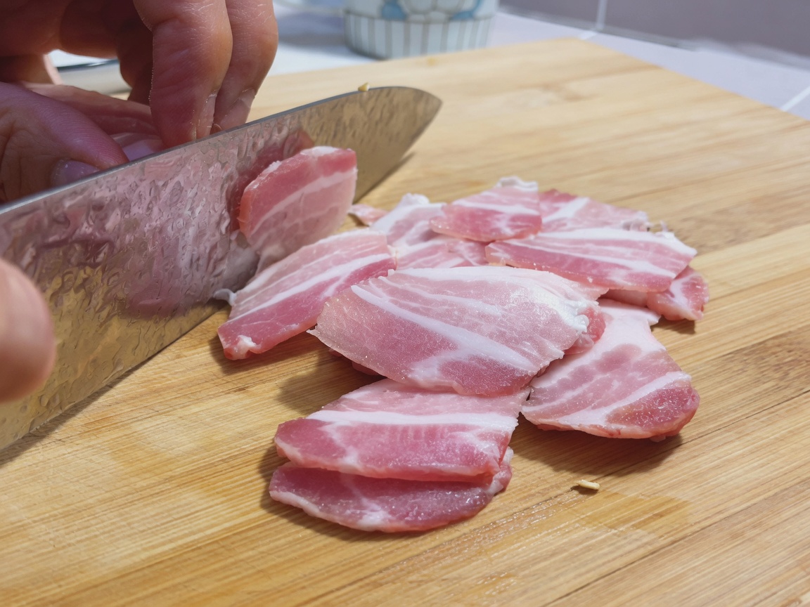 도마 위에 놓인 삼겹살과 식칼.