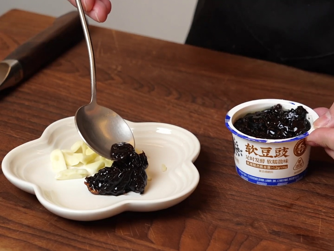 그릇에 담긴 습식 발효 흑콩을 작은 접시에 덜어놓은 모습.
