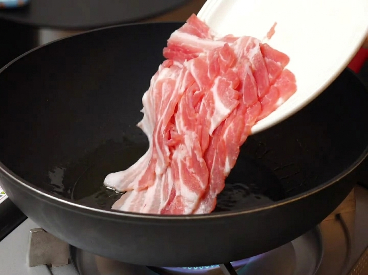 뜨거운 팬에 삼겹살을 넣고 굽는 모습.