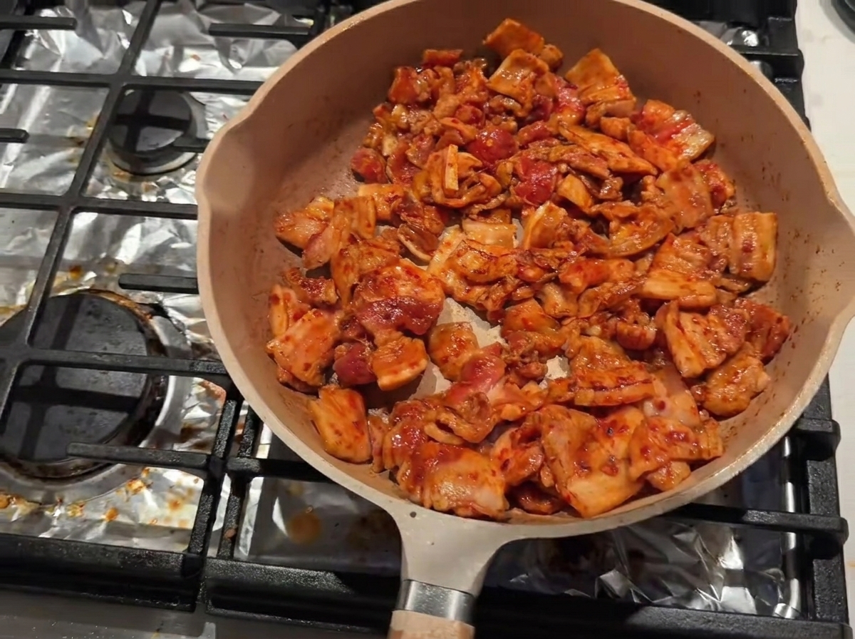팬 가장자리에 맛술을 둘러 풍미를 더하며 굽는 모습.