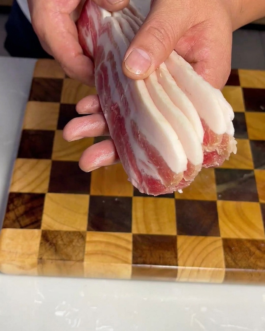 도마 위에 가지런히 놓인 일정한 두께의 삼겹살.