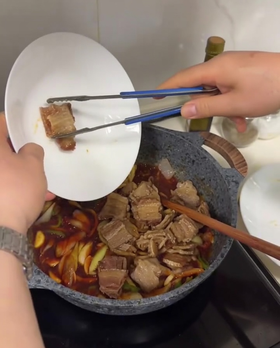 끓는 양념에 구워둔 고기를 넣고 섞는 모습.