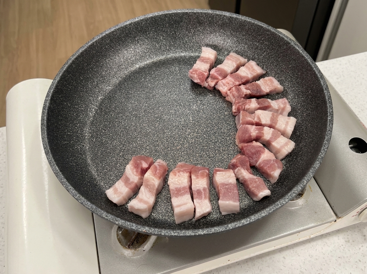 차가운 팬에 삼겹살을 둥글게 배치하고 있는 모습.