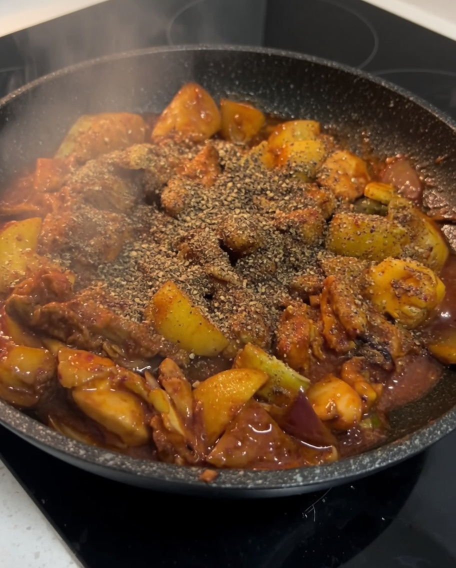 완성된 닭갈비 위에 들깻가루를 뿌리는 모습.