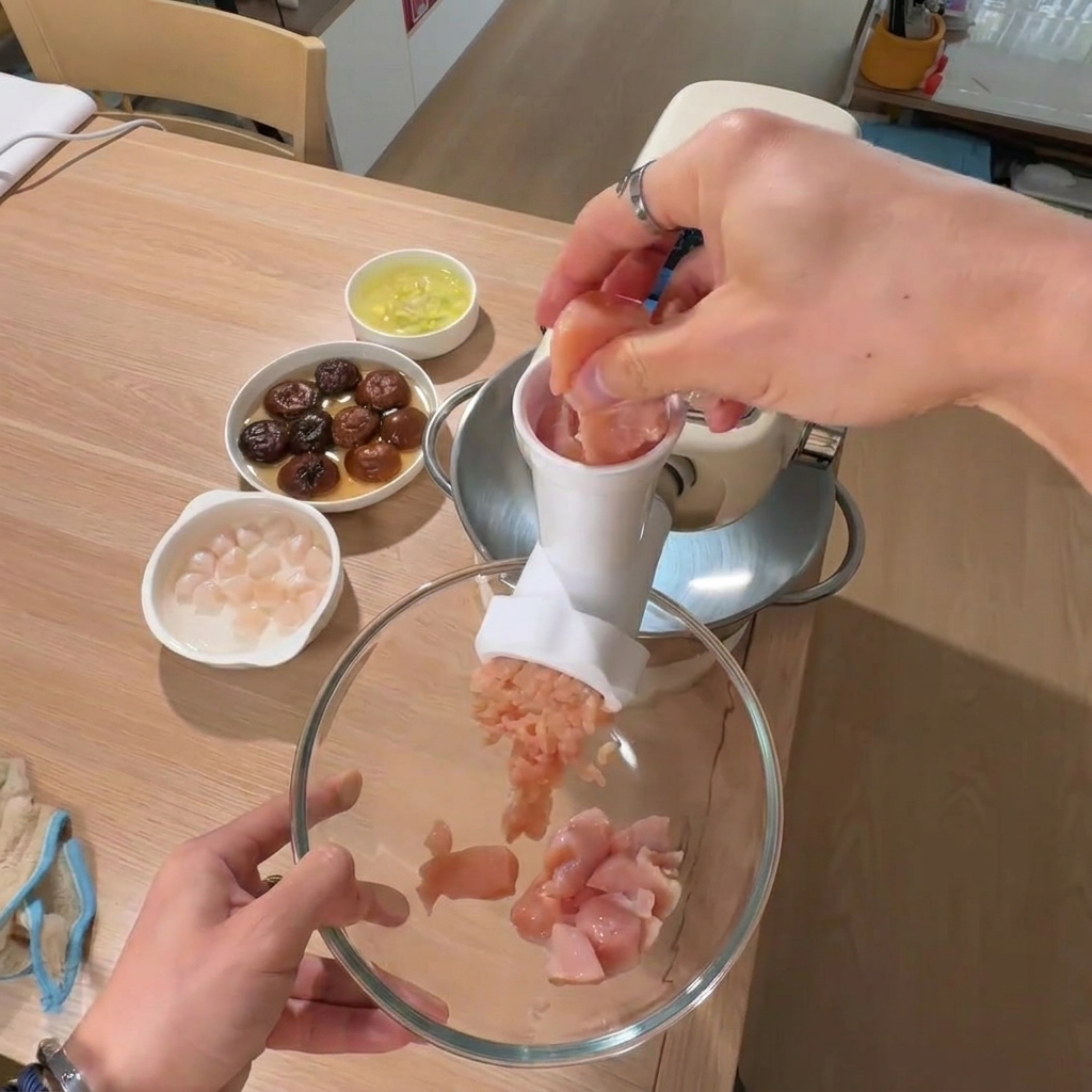 큰 볼에 다진 닭가슴살을 담고 배경으로 불린 버섯과 관자가 놓여 있는 모습.