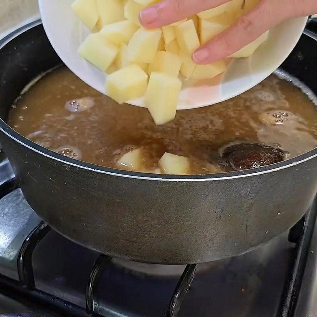 깍둑썰기한 감자를 된장찌개에 넣는 모습