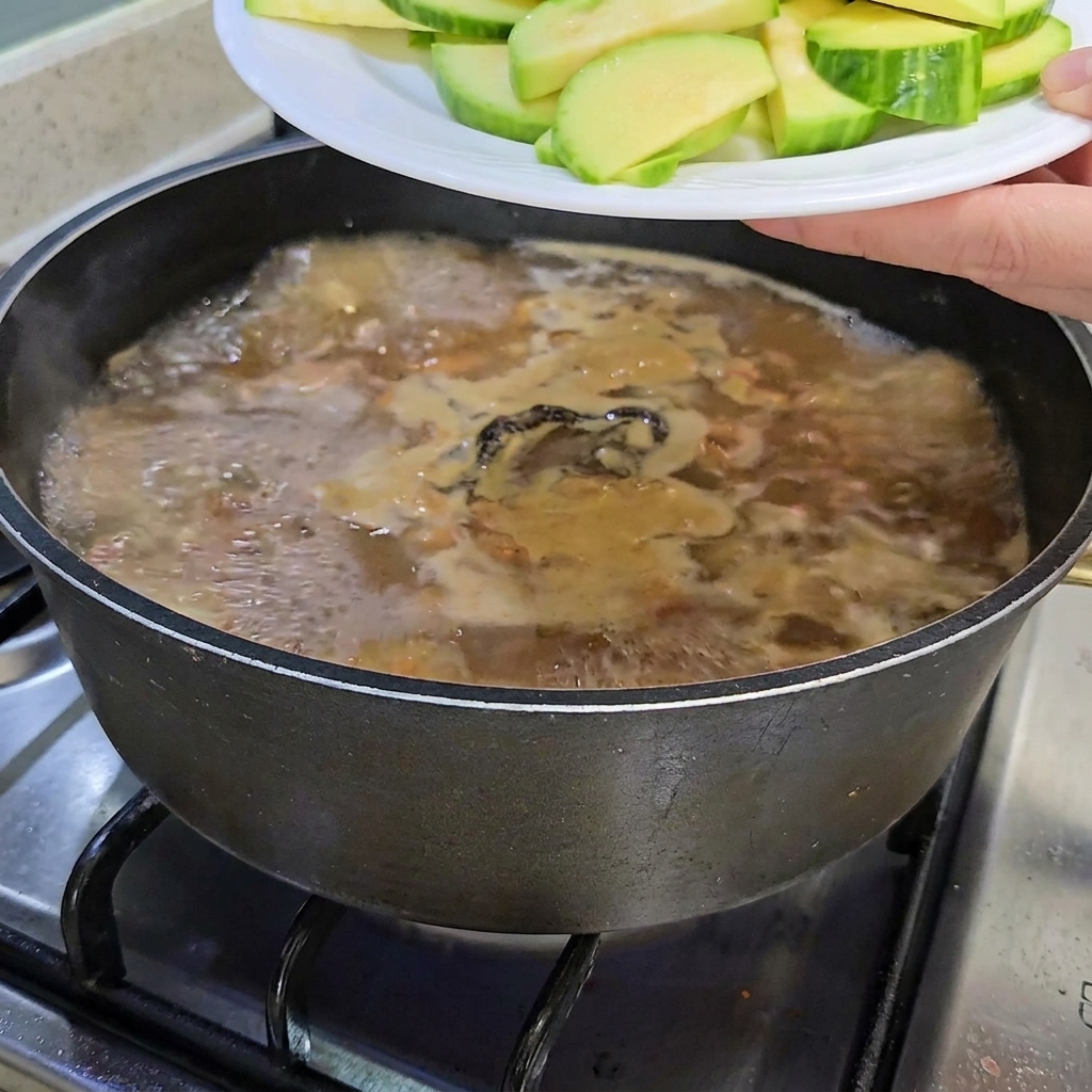 애호박과 팽이버섯을 찌개에 넣는 모습