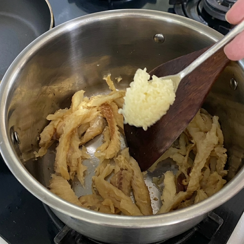 볶는 북어에 다진 마늘을 넣는 모습.