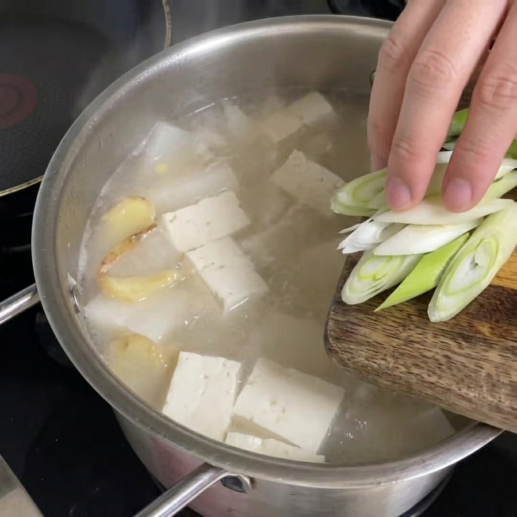 완성된 북어국에 송송 썬 대파를 올리는 모습.
