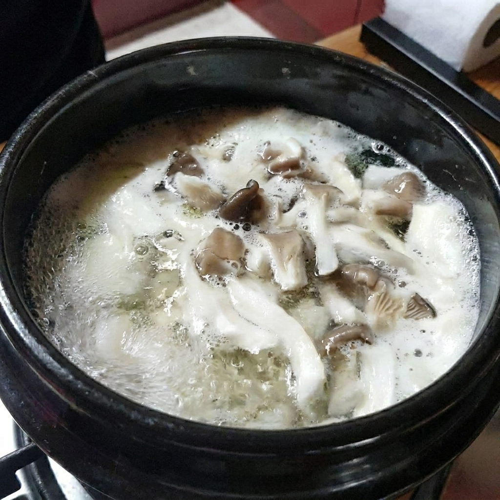 끓는 찌개에 썬 애호박을 넣는 클로즈업 사진.