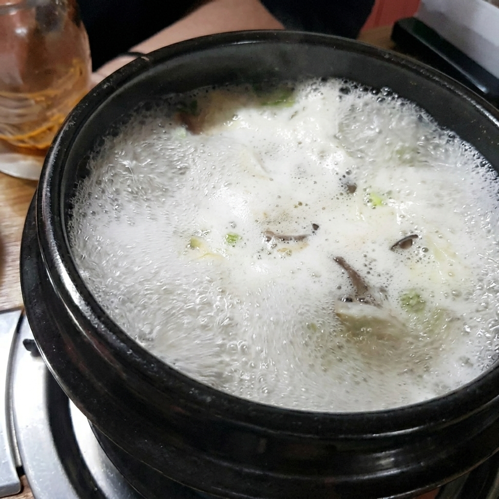 뚝배기 안의 육수에 갈색 된장을 푸는 모습.