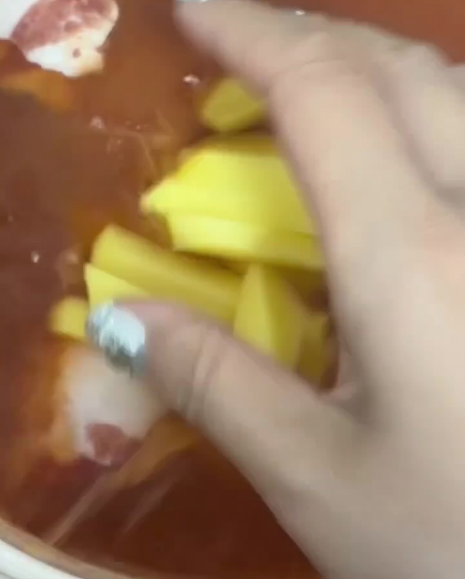 붉은 국물에 채 썬 감자를 넣는 모습.